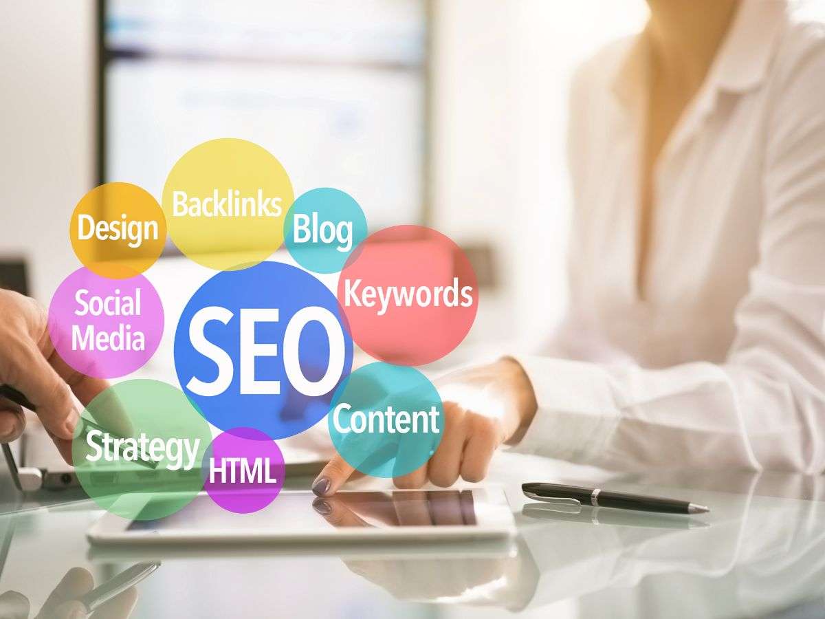 colorful circles with SEO, keywords, Social media, backlinks, strategy, blog, design, overlaying business woman in planning meeting gaining advice on marketing for therapists 